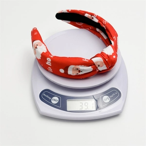 Detail view of a knotted red Christmas headband with Santa print showing 39.1g weight