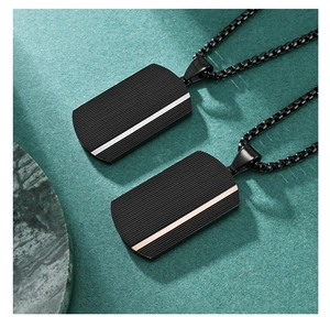 Detailed view of black rectangle dog tag pendants with silver and rose gold ripple textures