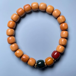 Detailed shot of sandalwood bead bracelet with green and red accents and gold spacers