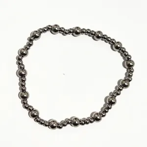 Vista macro de las cuentas de acero inoxidable pulido en esta pulsera minimalista