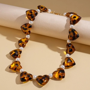 Close-up of amber leopard heart beads and white pearls on a stylish beaded necklace