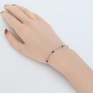 Detailed view of a silver 925 bracelet with four rectangular blue gemstones on a wrist