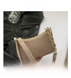 Detail of beige crocodile pattern handbag with resin chain and slim leather shoulder strap