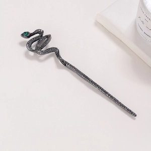 Snake-shaped black metal hair pin with green gemstone and textured scale pattern