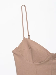 Detail of adjustable spaghetti straps and structural seams on a khaki cotton linen dress
