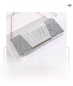 Close-up of silver sequin evening clutch bag with metallic chain and pleated fabric detail