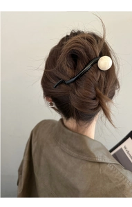 Détail d'un pic à cheveux noir ondulé avec perle marbrée pour chignons élégants