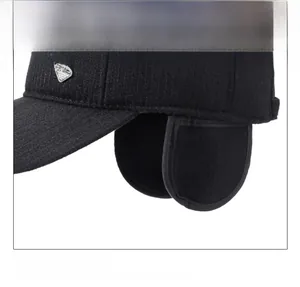 Close-up of black winter hat featuring protective ear flaps and a metallic diamond logo