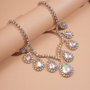 Elegant silver necklace with teardrop AB crystals on a pink pedestal display