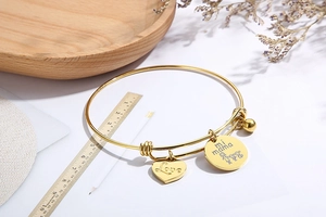 Detail of adjustable gold heart bracelet with Love and mi mama engraved pendants
