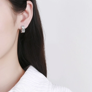 Sparkling silver butterfly hoop earrings with full pavé crystals worn by model