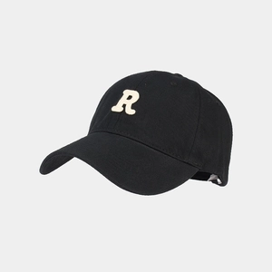 Dettaglio del cappellino da baseball in cotone nero con patch R bianca e trama canvas