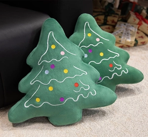 Detailed close-up of plush Christmas tree pillows with colorful embroidered decorations