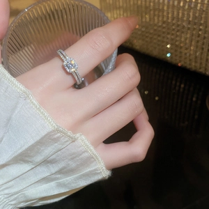 Detail of princess cut zircon ring with micro-paved diamonds on a slim silver band