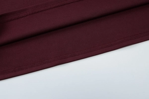Vue détaillée de l'ourlet et de la texture du tissu de la robe rouge bordeaux