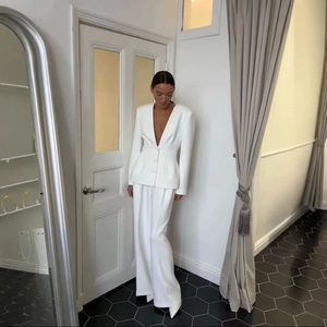 Elegant white two-piece suit with deep V-neck blazer and wide-leg trousers for women