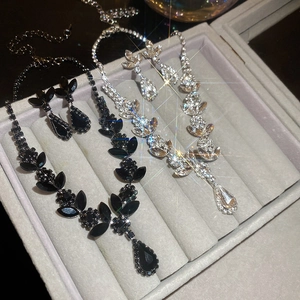 Close-up of diamond wheat-ear pendant necklace and earring sets in black and white