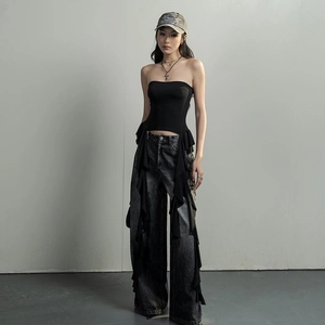 Détail du haut bandeau noir à volants porté avec un jean large en denim délavé