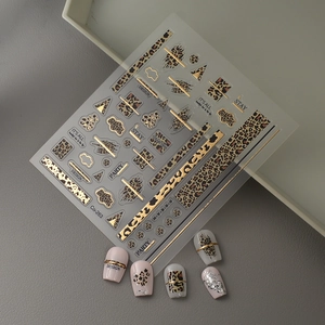 Detail of 5D gold leopard print nail stickers with artistic lettering and metallic lines