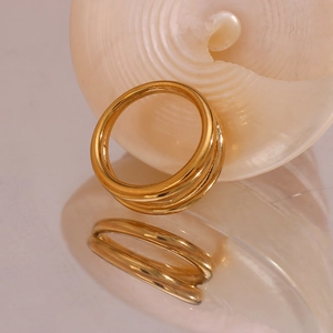 Macro shot of minimalist 18K gold plated triple layered ring on reflective surface