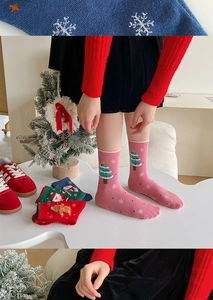 Close-up of knit Christmas socks featuring colorful gingerbread man and tree embroidery