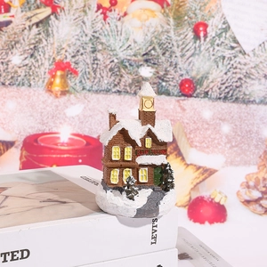 Cozy snow-covered resin Christmas house decoration featuring Rain Station tower on books