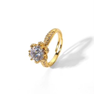 Détail macro d'une bague ajustable dorée avec un grand zircon serti à six griffes