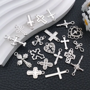 Flat lay of diverse silver alloy cross pendants with intricate hollow and floral designs
