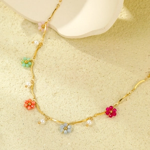 Collier doré avec fleurs en perles colorées et petites perles blanches sur chaîne fine