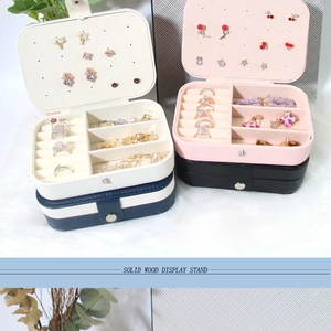 Multi-compartment travel jewelry box featuring earring plates and ring slots in various colors