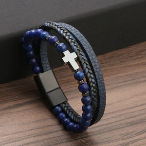 Macro view of blue stone beads and stainless steel cross charm on a braided bracelet