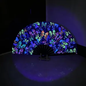 Detail of bamboo folding fan with fluorescent butterfly pattern glowing under UV light