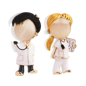 Detail of cartoon doctor and nurse brooches with opal faces and enamel finish