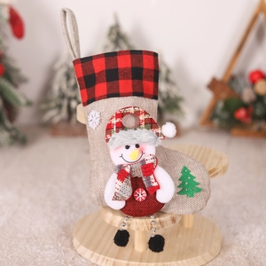 Detail of burlap Christmas stocking featuring a 3D snowman with red and black plaid trim