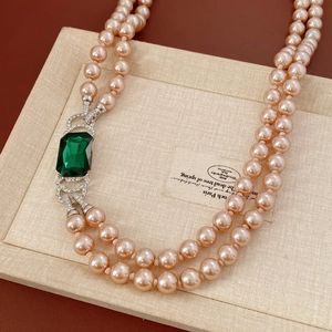 Dettaglio della collana di perle champagne a due fili con chiusura a smeraldo e cristalli