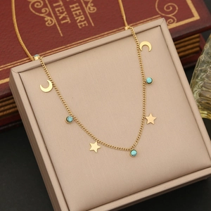 Detailed close-up of gold star and moon necklace with turquoise beads on a jewelry box
