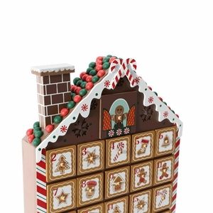 Detail of wooden gingerbread house advent calendar with numbered candy-themed drawers
