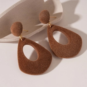 Gros plan de boucles d'oreilles gouttes floquées marron avec texture mate et style rétro