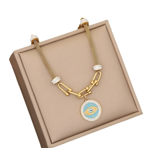 Golden mesh chain necklace with blue evil eye pendant and diamonds on jewelry box