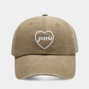 Detail shot of white heart embroidery with Paris text on khaki washed baseball cap
