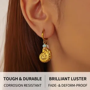 Détail de la boucle d'oreille coquillage doré avec perles sur l'oreille d'un modèle