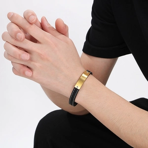 Men's black leather bracelet with brushed gold metal plate on male wrist