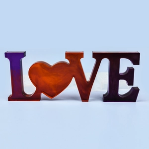 Macro shot of LOVE letter resin mold with finished heart-shaped decorative casting