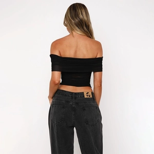 Sexy black off-shoulder mesh top paired with high-waisted grey jeans shown from behind
