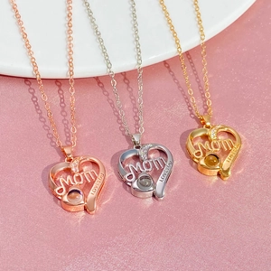 Detailed close-up of heart-shaped MOM necklaces with 100 languages I love you projection stone