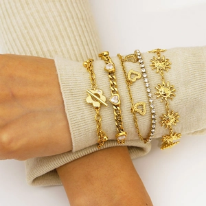 Elegant gold-layered bracelets with zircon charms set against a soft knit background