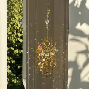 Evil eye sun and moon crystal suncatcher reflecting rainbow prisms on a wall