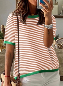 Détail d'un pull rayé orange et blanc avec col et poignets en tricot côtelé vert