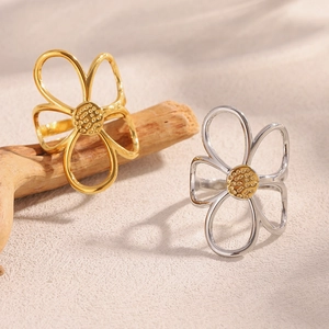 Detail of hollow floral rings in gold and silver finish with textured flower centers