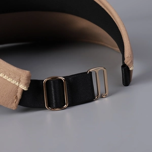 Detailed close-up of adjustable strap with gold metal buckle on sun visor hat